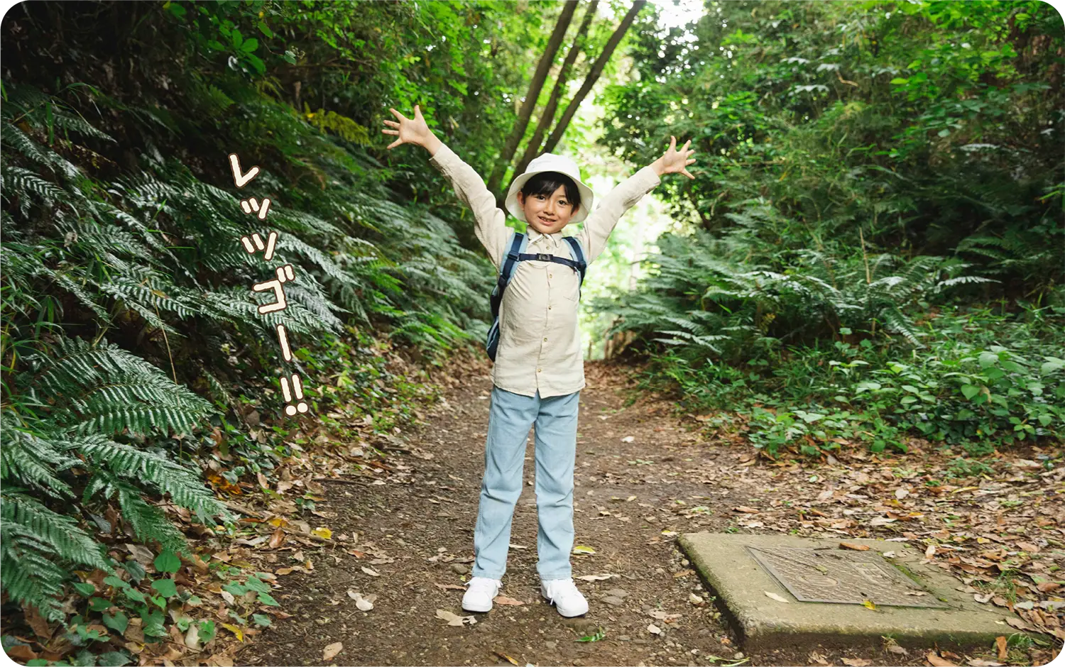 草木が生い茂る宮ノ前峠入口の前に立つ少年